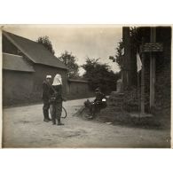 Infanterie - Trois soldats au pied du calvaire sur la route de la commune de Briot dans l'Oise. [légende d'origine]