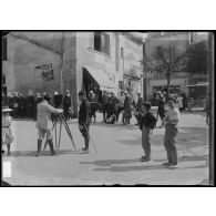 Un soldat se fait prendre le portrait par un photographe ambulant sur la place d'un village. [légende d'origine]