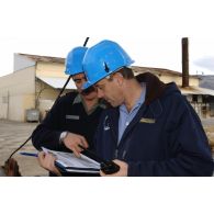 Embarquement des véhicules pour la relève de l'opération Licorne (8e mandat) : un capitaine de corvette du DTIM s'entretient avec un lieutenant-colonel, réserviste de la 27e BIM.