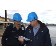 Embarquement des véhicules pour la relève de l'opération Licorne (8e mandat) : un capitaine de corvette du DTIM  s'entretient avec un lieutenant-colonel, réserviste de la 27e BIM.