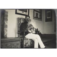 Mon bureau à Alger. Dans le bureau de Bertrand. Le bouquet de fleurs que je porte n'est autre chose qu'un défaut de la plaque. [légende d'origine]