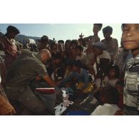 Des enfants cambodgiens reçoivent des cadeaux de la part des soldats français de l'ONU.