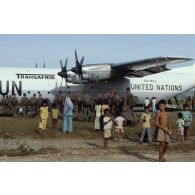 Les enfants cambodgiens saluent les soldats français qui embarquent à bord d'un Hercule C-130.