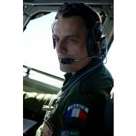 Portrait du lieutenant-colonel pilote d'E3F du 36e EDCA (escadron de détection et de contrôle aéroporté) aux commandes en cabine de pilotage, lors d'une mission de contrôle aérien sur la Libye à bord d'un avion de détection Awacs.