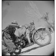 Un goumier du IIe Tabor du 1er GTM (groupe de tabors marocains) de la 1re DMM (division de marche du Maroc) démarre une Moto-Guzzi GT17 prise à l'armée italienne, dans le secteur de Siliana.
