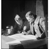 Le lieutenant-colonel Mazoyer, commandant le 9e RCA (régiment de chasseurs d'Afrique) rattaché à la BLM (brigade légère mécanique) et un lieutenant, font un point de situation sur une carte au poste de commandement du groupement Mazoyer, dans le secteur de Fondouk el-Okbi.
