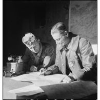 Le lieutenant-colonel Mazoyer, commandant le 9e RCA (régiment de chasseurs d'Afrique) rattaché à la BLM (brigade légère mécanique) et un lieutenant, font un point de situation sur une carte au poste de commandement du groupement Mazoyer, dans le secteur de Fondouk el-Okbi.