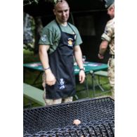 Des soldats britanniques du Rifles regiment préparent un barbecue lors d'une fête à Tapa, en Estonie.