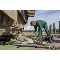 Un soldat fixe un char Leclerc du 501e régiment de chars de combat (501e RCC) sur la remorque d'un tracteur routier porte-chars de 50 tonnes (TR-PC 50) à Tapa, en Estonie.