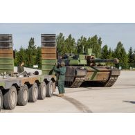 Des soldats guident le chargement d'un char Leclerc du 501e régiment de chars de combat (501e RCC) à bord d'un tracteur routier porte-chars de 50 tonnes (TR-PC 50) à Tapa, en Estonie.