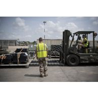 Des éléments du 1er RTP et du GTO embarquent une palette de fret au moyen d'un chariot de levage sur la piste de l'aéroport de N'Djamena.