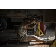 Portrait d'un mécanicien en intervention technique sur un VAB au sein de l'atelier de réparation de N'Djamena.