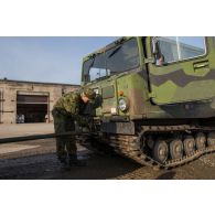Un soldat estonien encadre le chargement d'un véhicule articulé chenillé (VAC) Bandvagn 206 à bord d'un camion porteur polyvalent logistique (PPLOG) à Jõhvi, en Estonie.
