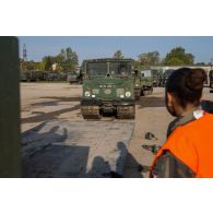 Un soldat guide le chargement d'un véhicule articulé chenillé (VAC) Bandvagn 206 à bord d'un camion porteur polyvalent logistique (PPLOG) à Jõhvi, en Estonie.