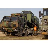 Un soldat guide le chargement d'un véhicule articulé chenillé (VAC) Bandvagn 206 à bord d'un camion porteur polyvalent logistique (PPLOG) à Jõhvi, en Estonie.