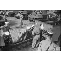Des légionnaires de l'escadron antichars du 1er REC (régiment étranger de cavalerie) attèlent un canon de 57 mm M1 à un scout-car M3A1 à l'issue de la prise d'armes près de la forêt de la Mamora.