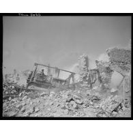 Une nivelleuse déblaie un terrain dans le village de Formia.