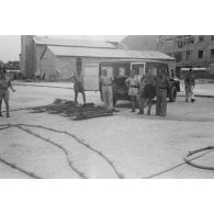 Sur un quai utilisé par les hydravions Dornier DO-24 du Seenotstaffel 7, une ambulance et des brancards attendent des blessés d'une unité de transport.