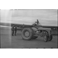 Sur la piste du terrain d'aviation, un tracteur agricole tracte le planeur DFS-230 du Luftlandegeschwader 1 (8./LLG 1) vers un nouvel emplacement.