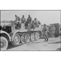 Un semi-chenillé Sd.kfz.7 s'apprête à tracter une pièce de 8,8 cm FlaK que les artilleurs viennent d'atteler.