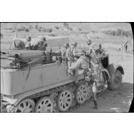Un semi-chenillé Sd.kfz.7 s'apprête à tracter une pièce de 8,8 cm FlaK que les artilleurs viennent d'atteler.