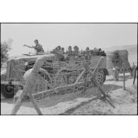 Un semi-chenillé Sd.kfz.7 s'apprête à tracter une pièce de 8,8 cm FlaK que les artilleurs viennent d'atteler.