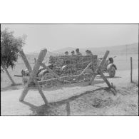 Un semi-chenillé Sd.kfz.7 s'apprête à tracter une pièce de 8,8 cm FlaK que les artilleurs viennent d'atteler.