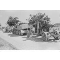 Un semi-chenillé Sd.kfz.7 s'apprête à tracter une pièce de 8,8 cm FlaK que les artilleurs viennent d'atteler.