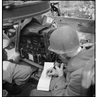 De son poste de commandement installé dans une voiture blindée, un colonel du 2e RD suit la progression des chars sur la carte et transmet ses ordres par radio.