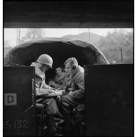 De son poste de commandement installé dans une voiture blindée, un colonel du 2e RD suit la progression des chars sur la carte et transmet ses ordres par radio.