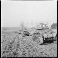 Une colonne de chars légers Hotchkiss M35 H du 4e Cuirassiers ou 18e RD est photographiée en plan général de trois quarts arrière alors que les chars progressent sur un terrain plat.