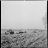 Une colonne de chars légers Hotchkiss M35 H du 4e Cuirassiers ou 18e RD est photographiée en plan général de trois quarts avant alors que les chars progressent sur un terrain plat.