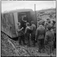 Plan général de soldats du 6e Cuirassiers qui déchargent un camion de son matériel de projection.