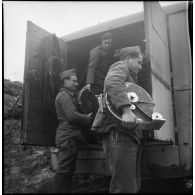 Plan général de soldats du 6e Cuirassiers qui déchargent un camion de son matériel de projection.