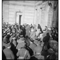 Plan général d'une foule de militaires de la 55e DI rassemblée à l'entrée d'un bâtiment.