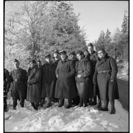 Photographie de groupe d'officiers et de sous-officiers de la 55e DI dans un paysage enneigé.
