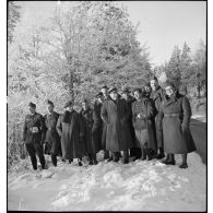 Photographie de groupe d'officiers et de sous-officiers de la 55e DI dans un paysage enneigé.