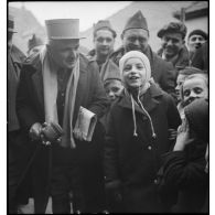 Un capitaine de la 55e DI est photographié avec des enfants.