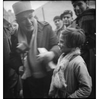 Un capitaine de la 55e DI est photographié avec des enfants.