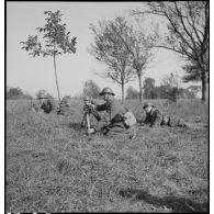 Plan général d'un soldat qui sert un mortier de 60 mm M35 photographié de trois quarts avant.