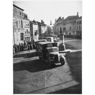 Les ambulances Chevrolet de la 1re section sanitaire de volontaires américains (SSVA), qui porte le nom de general John J. Pershing, arrivent sur la place Jeanne d'Arc à Vic-sur-Seille pour une présentation aux autorités.
