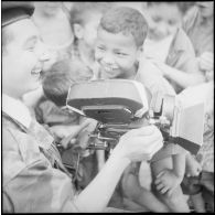 Portrait d'un cameraman du SCA d'Alger entouré d'enfants.
