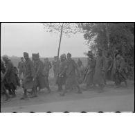 Une colonne de prisonniers avance péniblement.