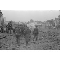 A Chateau-Thierry, des prisonniers français sont escortés par des fantassins armés de fusils Mauser 98 k.
