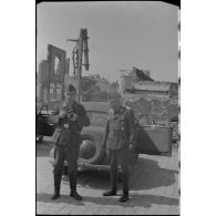 Des reporters de la Luftwaffe dans une rue dévastée de Rethel.