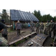Un instructeur estonien donne un cours de bûcheronnage à des soldats français au chalet de Kollassaare en forêt de Järvama, en Estonie.