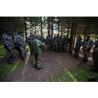 Un instructeur estonien donne un cours de bûcheronnage à des soldats français en forêt de Järvama, en Estonie.