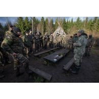 Un instructeur estonien donne un cours de bûcheronnage à des soldats français en forêt de Järvama, en Estonie.