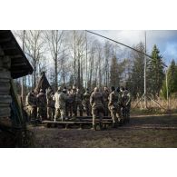 Un instructeur estonien donne un cours de bûcheronnage à des soldats français en forêt de Järvama, en Estonie.