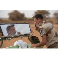 Un marsouin du 2e régiment d'infanterie de marine (RIMa) se rase dans le miroir d'une remorque-douche de campagne RD 3000 à Gao, au Mali.